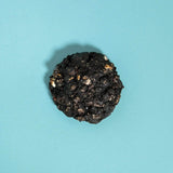 Cookies & Cream New York Cookie by Crumbs & Doilies with black cocoa dough and white chocolate chips on blue background